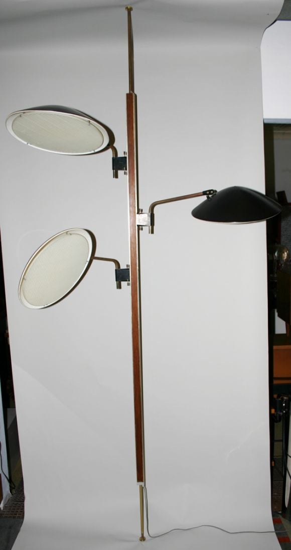 Floor to ceiling spring loaded pole lamp with three rotating saucer disks; plastic waffle pattern disk shade; brass and wood veneer details. Disks measure 15
