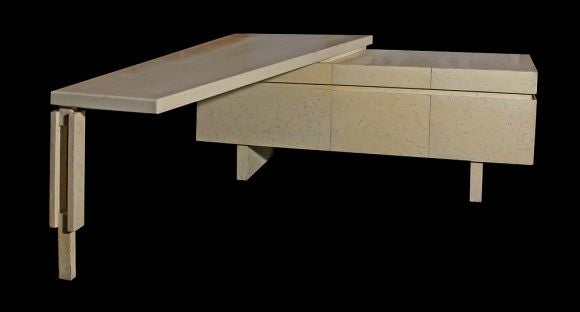 L-shaped desk by Billy Haines, 1960. Faux limestone finished case with a cantilevered desktop in ivory crackle finish lacquer. Three shallow drawers over three deep drawers, fitted for hanging file rails. Age appropriate wear to the lacquer. From