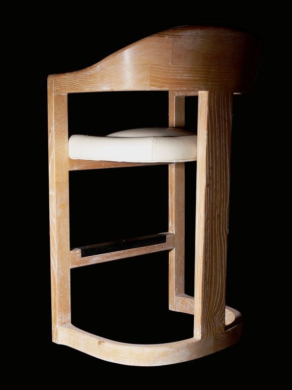 A set of three bleached, cerused oak bar stools in the famed Onassis style by Karl Springer, c.1960. Very solid, wide, comfortable and substantially made with bronze foot rest. Newly upholstered in ivory leather.