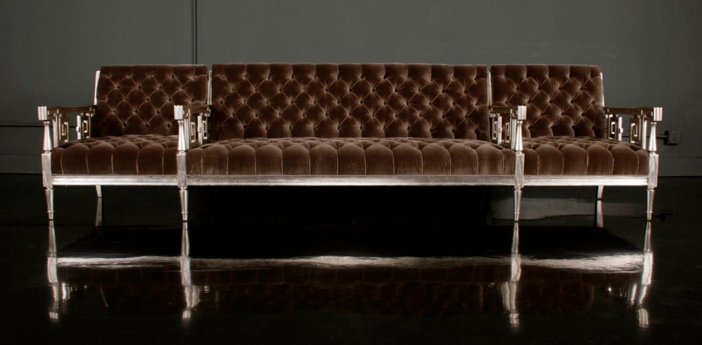 Silver Leafed Long Sofa by James Mont. Rare antiqued silver leaf three-sectioned sofa, one-person sections flank a four-person section with unusual arms carved with Classical and Asian decorative motifs, upholstered in tufted grey silk velvet.