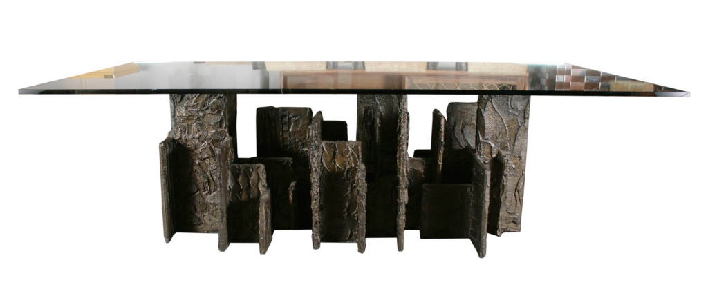 Magnificent glass topped sculpted bronze dining table by Paul Evans. Heavily sculpted base composed of intersecting planes reminiscent of a skyline. Sold with ten sculpted bronze chairs. Two arm chairs, model PE-105; and eight side chairs, model