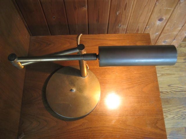 A classic, modernist, reading lamp by Nessen. Patinated brass, pivoting, rotating shade.