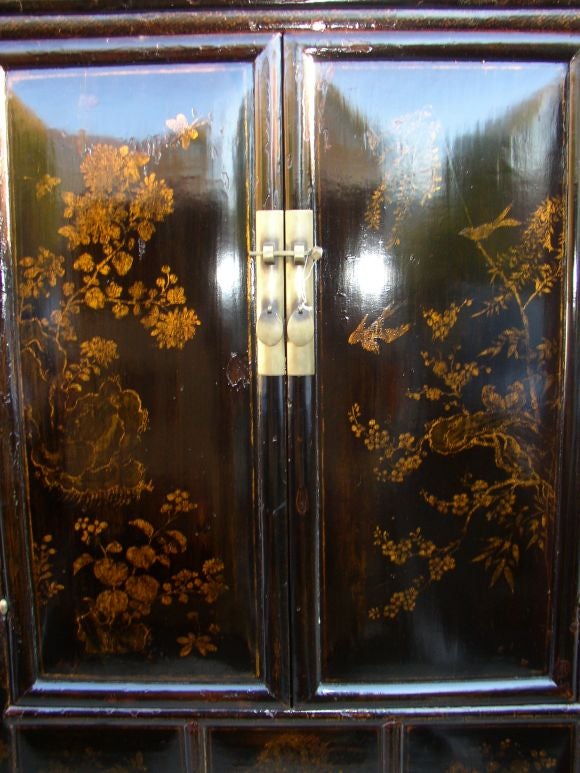 A very refined and elegant black lacquer armoire with fine hand painted birds and flowers motif in gold gilt. View our website at: www.greenwichorientalantiques.com for additional armoire selections.
