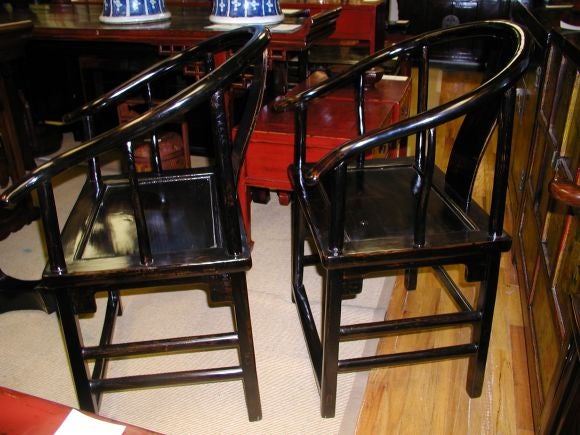 A Pair Of Black Lacquer Horseshoe Back Armchairs