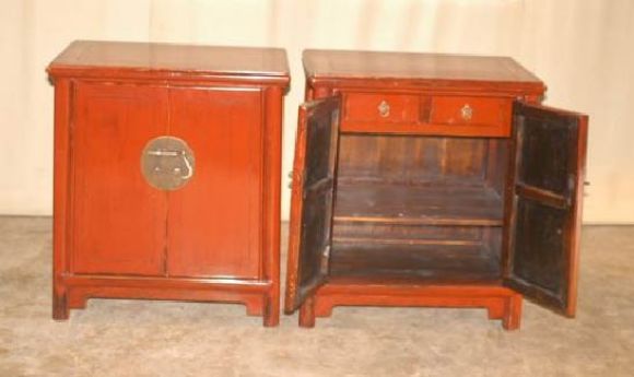 A pair of elegant red lacquer chests, with round brass fitting on a pair of doors. Beautiful form and color.