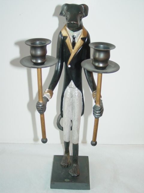 Two figural dog candlestick holders in cast iron,dressed as an English 19th century footman.