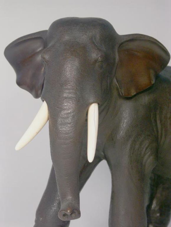 Wonderful lifelike bronze rendering of an elephant mid stride. Heavily detailed texture with applied ivory tusks, and makers seal to underside. Soft even patina, very beautiful.