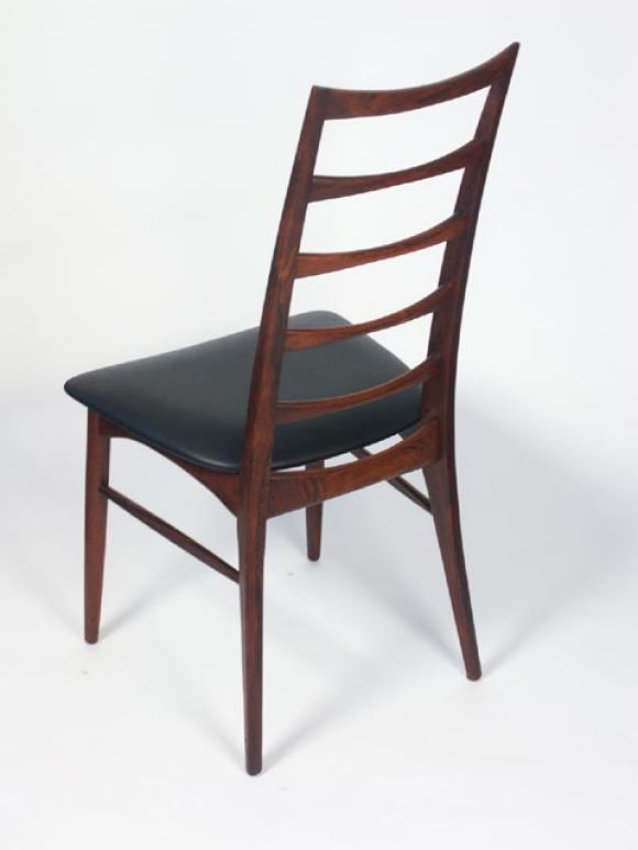 Tall ladder back dining chairs in the manner of Gio Ponti, by Kai Christiansen, Denmark 1960. Carved solid rosewood uprights with curved back slats. Black leatherette seat covers. Priced as a set of 6.