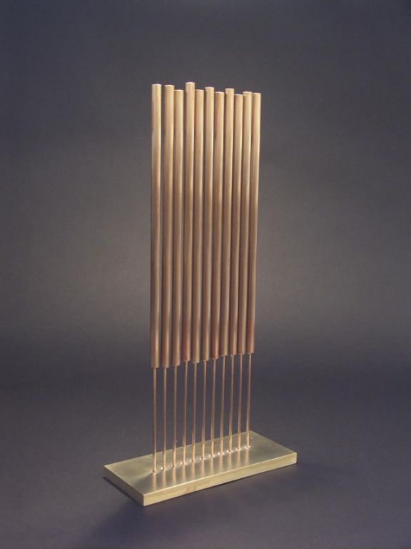 Heavy weight materials, with unusual proportions colaborate to amazing effect in this tonal sculpture by Bertoia. The thick naval brass base is pierced with 11 beryllium copper rods, topped with unusually long bronze chimes. The proportion and