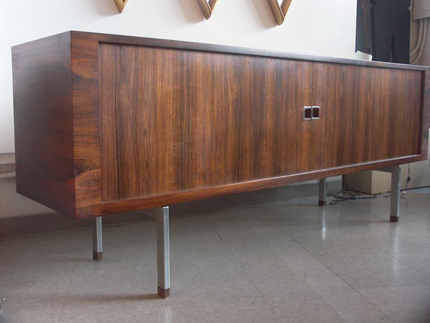 Typically impressive craftsmanship, in this wegner design for Ry Mobler, Denmark. The case, clad in matched rosewood veneers, features a pair of expertly tamboured sliding doors. The interior includes three storage compartments, the center with
