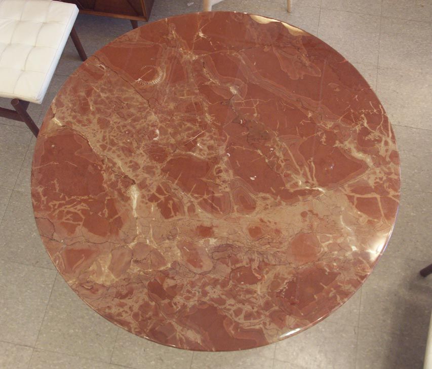 Manufactured by Knoll International in the 1990's, featuring a lustrous black tulip base. The long discontinued red marble top has incredible veining and prominenly features a mysterious spiral fossil of an ancient vertibrate. Absolutely top notch