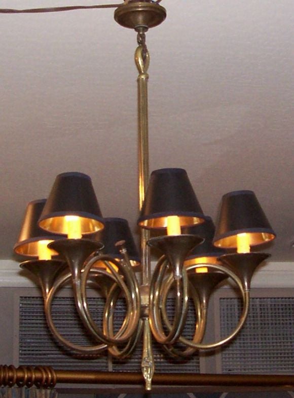 The standard in the form of a cluster of reeds, with six bugle-form arms terminating in circular wax pans and candle-form lights, suspending a tassel cast drop pendant; electrified.