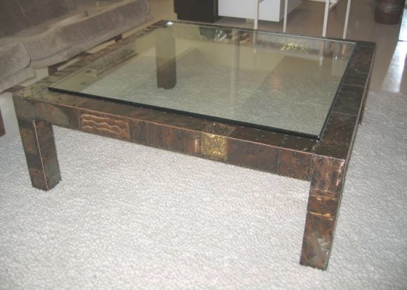 Impressive square coffee table in the style of Paul Evans, not signed. Assembled from a variety of hammered brass, copper and pewter plates.  Surface has been skillfully treated with intentional decorative scratches and nails, then enameled.