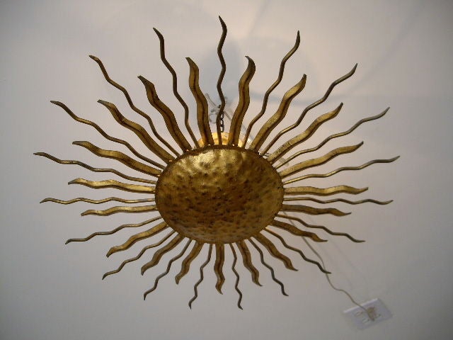 Gilt metal sun fixture. Can be mounted at ceiling, hung from a chain or hung on the wall as a sconce.