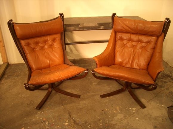 Pair of comfortable leather chairs with wood frames. One chair has arms.