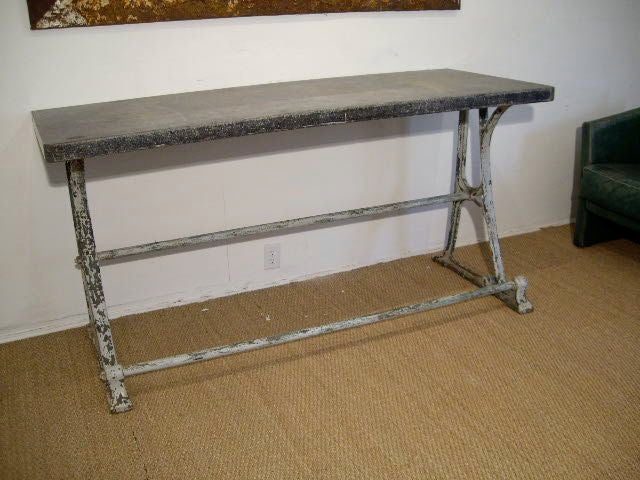 iron based console with original paint and thick blue stone top. great patina to base and stone. probably originally from a pastry or candy-making shop.
