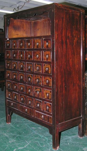 Elmwood chest with 39 drawers and open shelf above. Original lacquer finish, nicely distressed. Each drawer divided into three sections and marked in Chinese script. Dividers pull out.