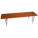 Walnut and brass bench by Hugh Acton