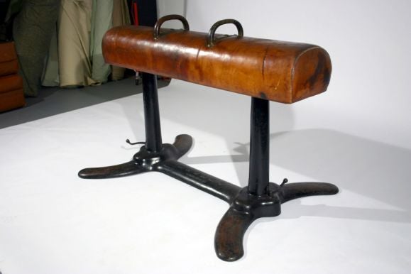 Extremely heavy cast iron pommel horse with worn leather and bronze handles.  One handle retains the original wrapped leather; the solid bronze is revealed on the other handle.  
