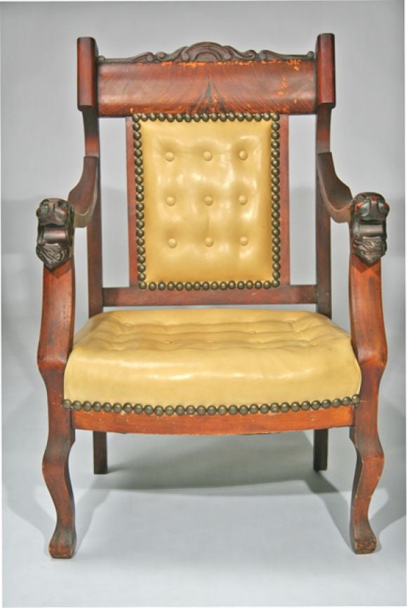 Sculpted wooden arm chair with lion's heads and button tufted leather upholstery.  <br />
Seat Height: 17