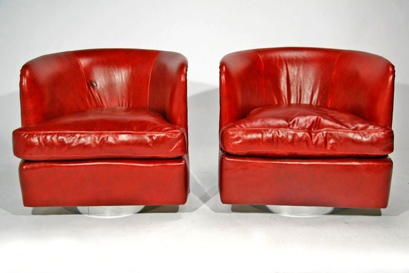 Pair of chrome sided swivel lounge chairs upholstered in a rich red leather. Designed by Milo Baughman for Thayer-Coggin. Seat Depth: 23