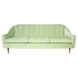 A celery velvet curved sofa by Paul McCobb