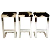 Set of three bar stools in chrome steel with cowhide seats