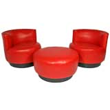 Pair of red leather swivel chairs with ottoman