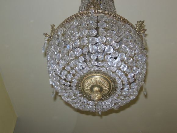 CHANDELIER OF CUTGLASS AND GILTMETAL WITH A CORONA OF NICELY CAST PALMETTES REPEATED ON THE PIERCED WAISTBAND.