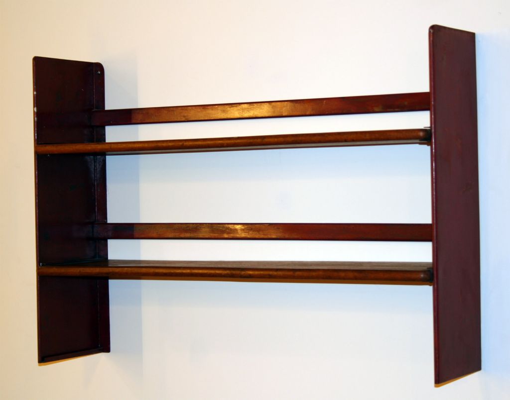 Wall mount shelving unit by Jean Prouve, with two oak shelves and a red metal frame.