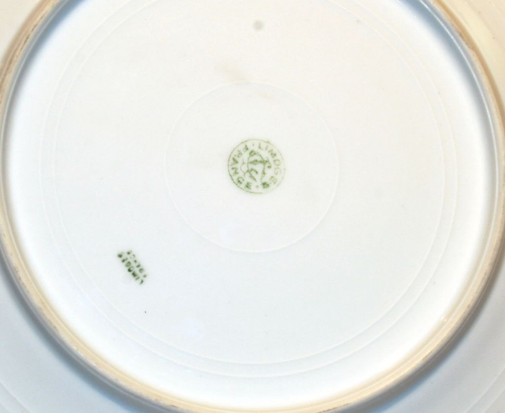 Fine bone china with gold leaf trim and simple dark blue detail, stamped Limoges France.