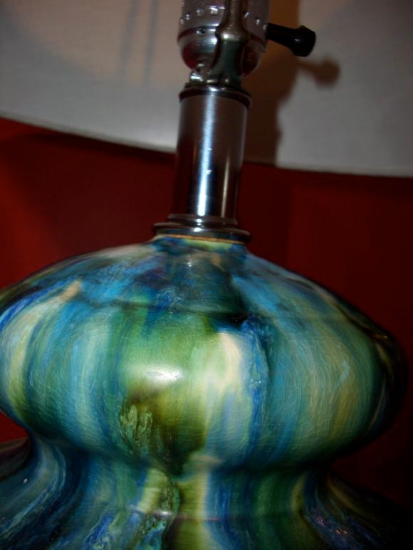 Beautifully glazed table lamp in blues and greens on black wooden base.  Glaze very reminiscent of Fulper pottery