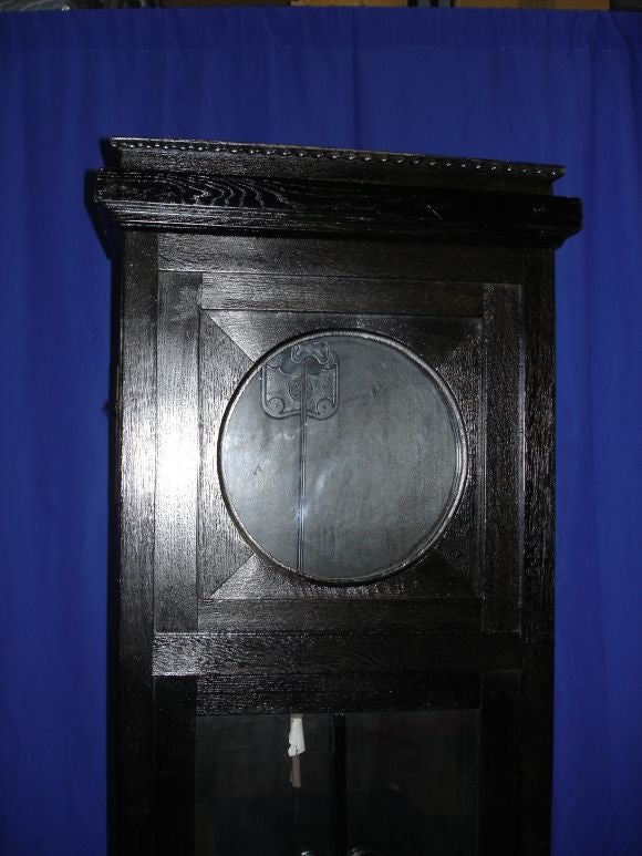 A unique case with arched muttons in the door. The clock face is simple brass.