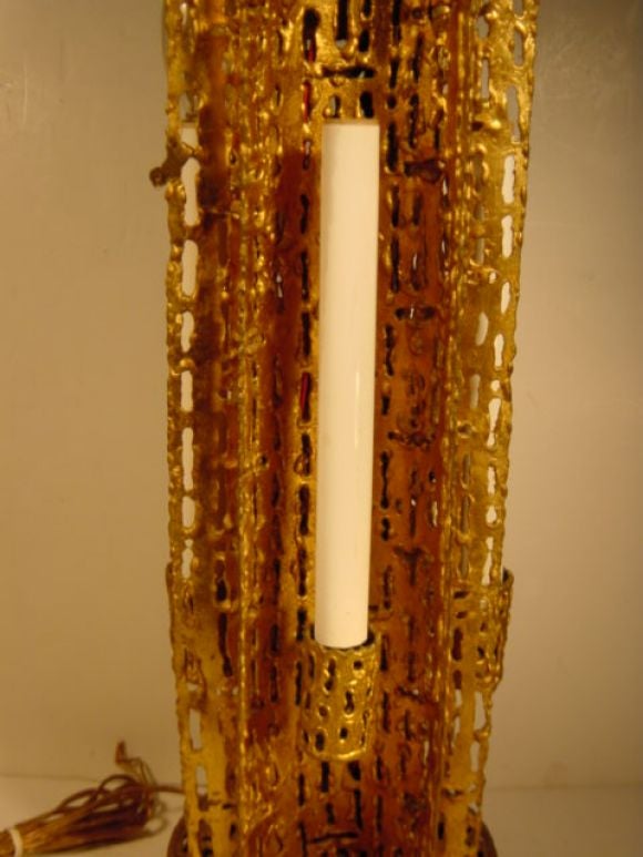 Gilt metal torch-pierced table lamp with four candle lamp lights to sides and socket on top. There is a riveted on 