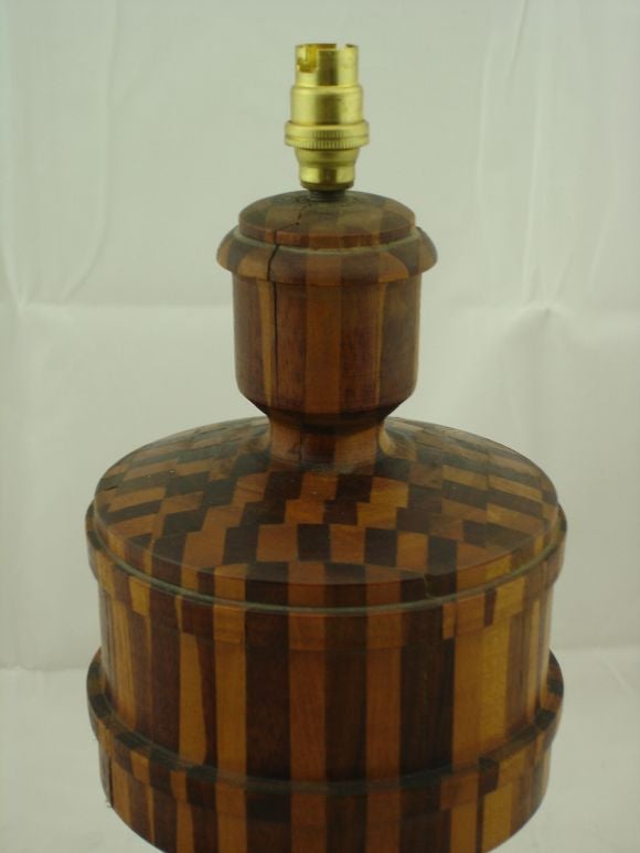 A Tramp Art Table Lamp with an intricate piecing of three different colors of wood.