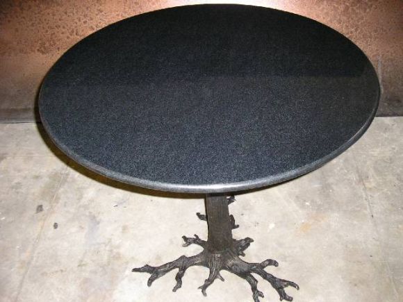 Table à plateau en granit avec base métallique en forme de racine d'arbre noueux