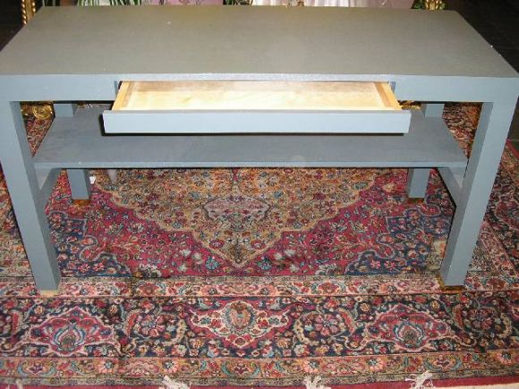 A custom table with pencil drawer wrapped and finished fine linen.