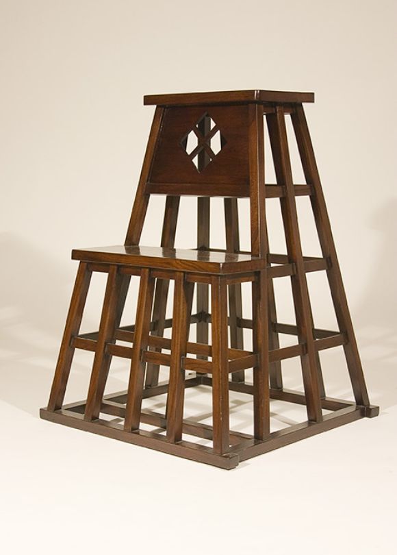 The architectural lattice of the tapering pyramid form with square section supports with thinner horizontal supports under a tall plank step/seat.  Below a second step with a pierced diamond quatrefoil and plank top step.  Dark elm color with some