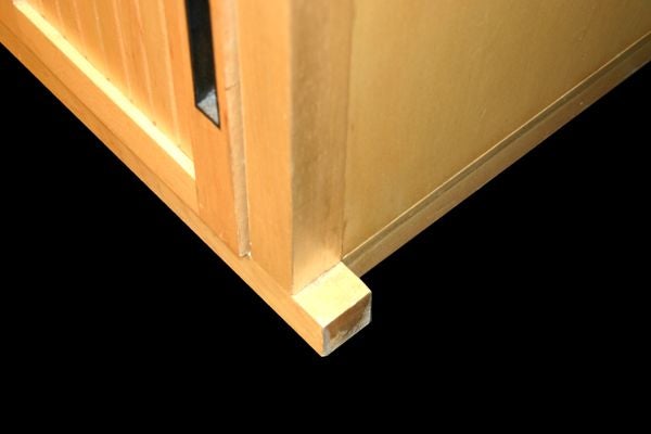 A JAPANESE MAPLE AND EBONY TANSU AS A BEDSIDE TABLE