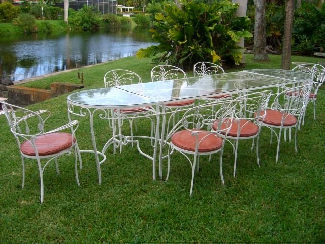 Incredible salterini wrought iron patio set.Set consist of 8 chairs, with one table and two demi-lune extensions as shown.Could also be used as a pair of consoles if desired.Great for indoors or outdoors.