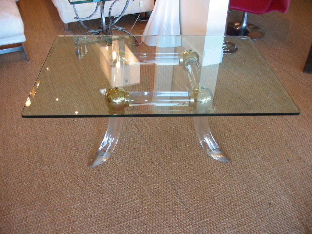 Fabulous thick solid lucite table base with brass fittings. Has thick rectangular beveled glass top.