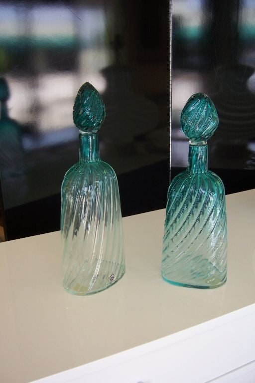Rare pair of Italian decanters in aqua turquoise tones fading to bottom - one is in triangular shape and one is in oval shape.  Matching stoppers to the decanters.<br />
<br />
Engraved signature and paper labels.