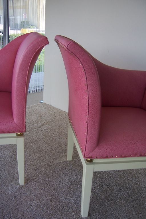 Rich pink leather chairs with elephant skin design, trimmed with brass studs and gold orbs on cream lacquered base.  These are wonderful for any room and even more beautiful in person.