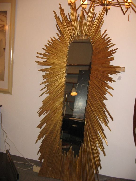 A fabulous very large scale wall mirror featuring a carved gilt wood stylized frame with central mirror. Italian circa 1930's. The pictures do not do this mirror justice..