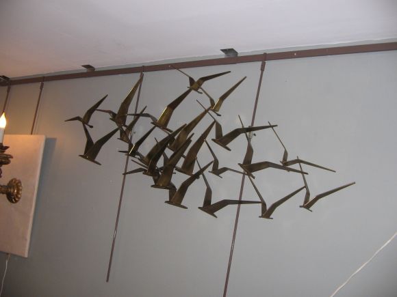 A bronze wall sculpture featuring layers of stylized flying birds. By Curtis Jere, 1968. Signed and dated by the artist.