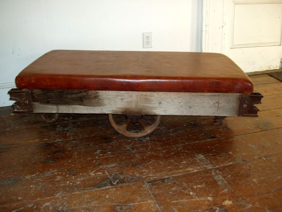 Reconstructed coal cart fitted with a well worn leather top.<br />
Each side has a single wheel and all original hardware details.<br />
Makes an unusual moveable coffee table.