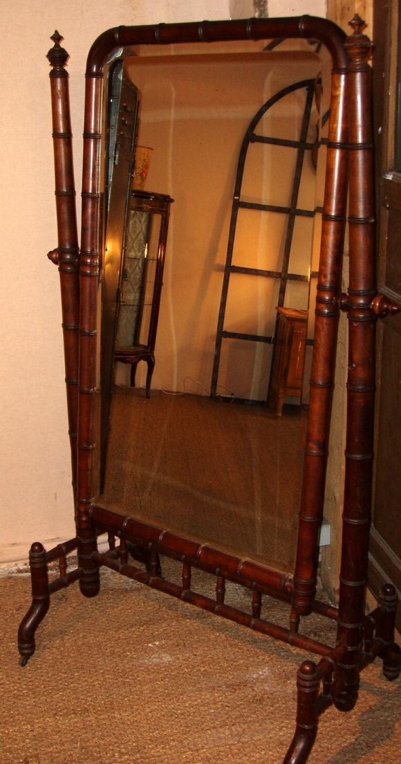 Wonderful tilting floor mirror.  Note the faux bamboo finish.<br />
Decorative finials top the side of the frame. Old mirror completes the look.