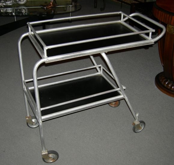 This stylish Aluminum and laminate rolling cart was featured on the DC3 aircraft, serving refreshments to the first generation of air travelers. Ours has the rare cocktail insert, which is cut out for various sizes of barware. The insert lifts out,