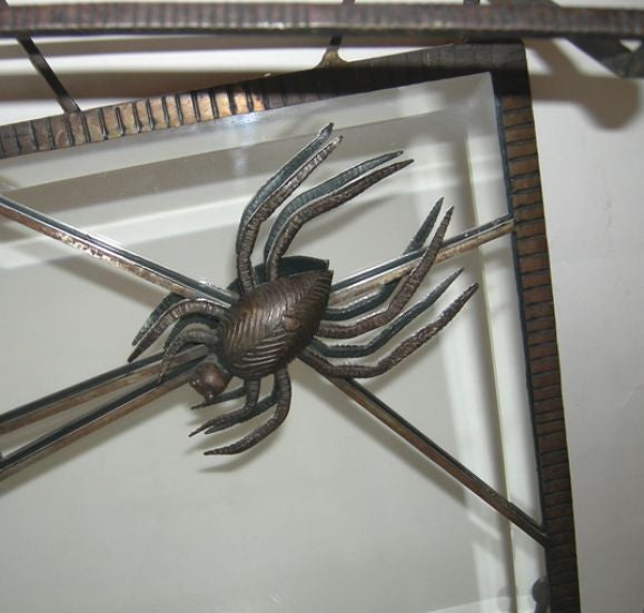 Just fantastic! The spider advances towards his prey in the midst of the off centered bevelled mirror. A hat rack floats above, while coat hooks extend the web on the bottom edge.There are two hanging loops on the upper corners for easy wall