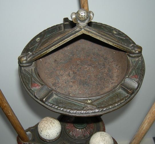 The ultimate way to improve your game! This charming standing ashtray has three holes, numbered 1, 2, and 3 to putt into. The stand has openings to house three vintage putters, and three balls. The golf ball and club motif is repeated in various